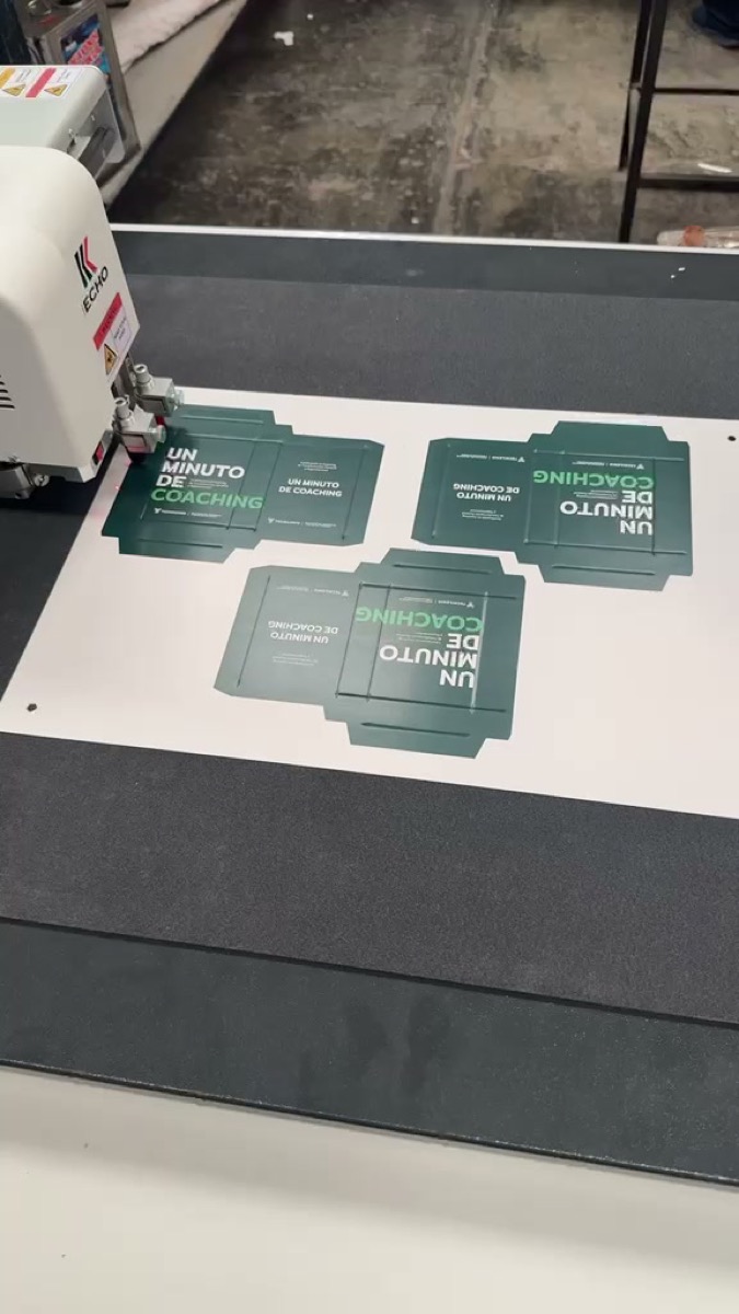 Pliego impreso con tres cajas troqueladas por corte digital sobre la mesa de vacío