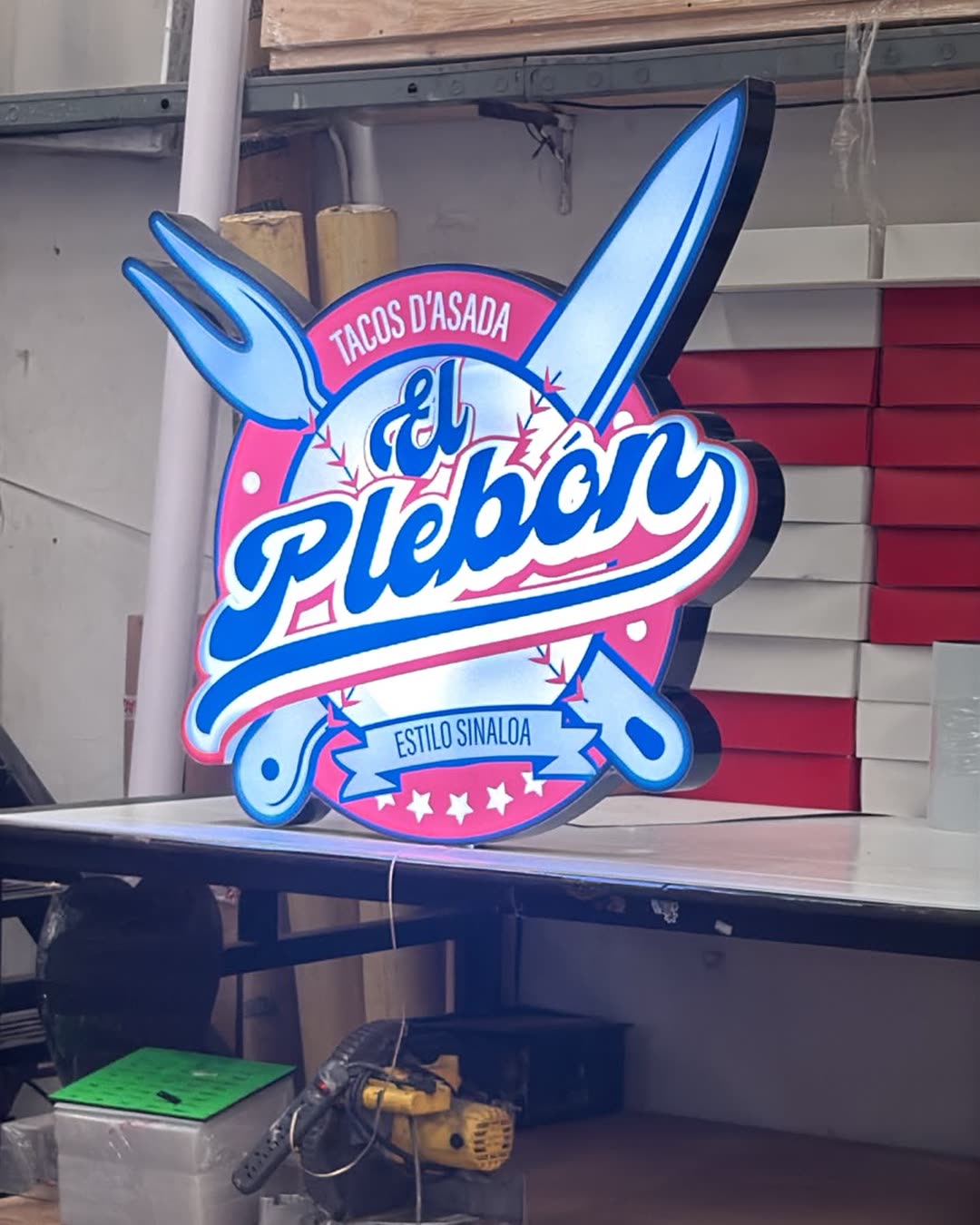 Letrero luminoso de El Plebón formado a figura, encendido en la planta de Impresos 24